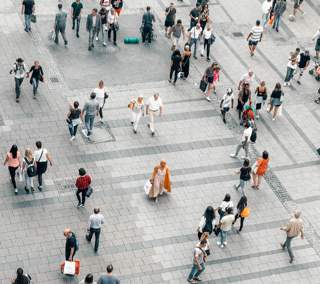 crowd of people walking across a town square