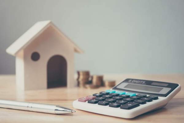 Home loan calclulator, model home, coins and pen