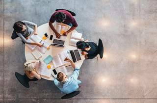 team of people working around a round table