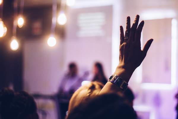 the ethics of responsibility room of people with one person holding their hand up