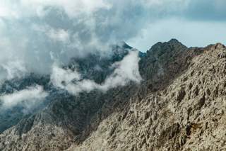 clouds drifting in over mountain peaks