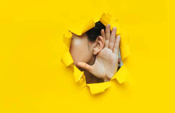 Confidential information person with hand to ear listening