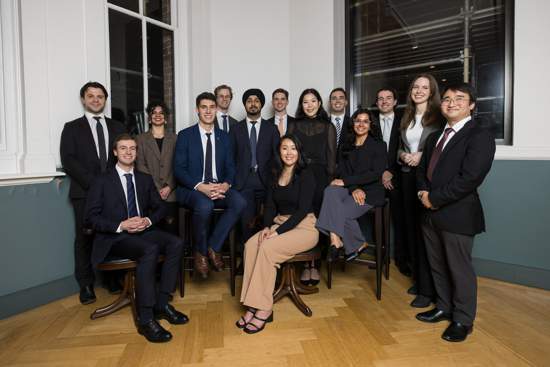 group of young professionals sitting and standing in a posed group shot