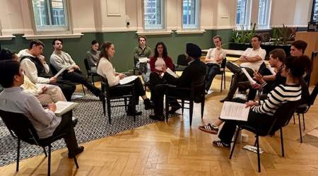 group of young people sitting in a circle of chairs